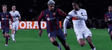 a group of soccer players are playing on a field with a qatar advertisement in the background