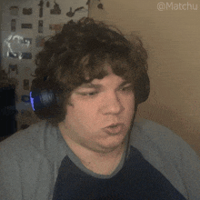 a man wearing headphones is making a funny face and has the hashtag @matchu on the bottom right