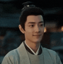 a man with a bun on his head is wearing a kimono .
