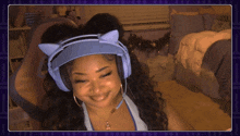 a woman wearing blue headphones with cat ears on her head