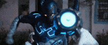 a man in a blue superhero costume is holding a blue circle in his hand