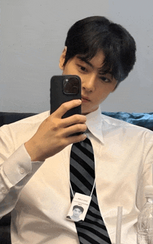a man in a white shirt and tie takes a selfie