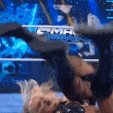 a woman is being thrown in the air by a wrestler in front of a sign that says gma own
