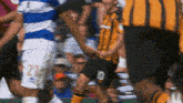 a soccer player with the number 21 on his shorts holds the hand of another player