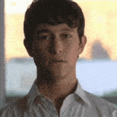 a close up of a man 's face with a white shirt on