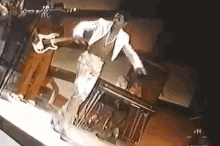 a man in a white jacket is playing a guitar
