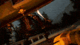a person in a yellow jacket is standing next to a robot with a flame coming out of it .