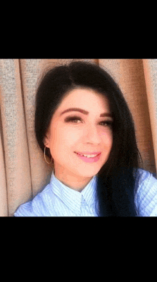 a woman wearing hoop earrings and a striped shirt is smiling