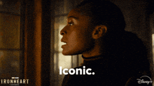 a woman is looking out a window and the words iconic are on the screen