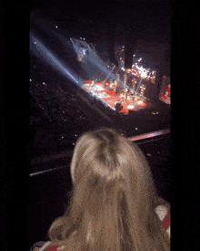 a blurry picture of a woman watching a concert in a stadium