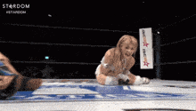 a woman in a wrestling ring with a sign that says five star fame on it