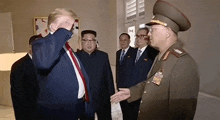 a group of men in suits and ties are standing next to each other and talking to each other .