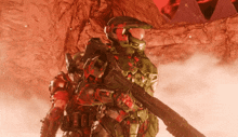 a man in a red and green armor is holding a rifle