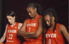 three female basketball players wearing red jerseys with the word fever on them