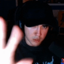 a man wearing a hat and headphones is making a funny face .