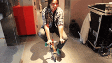 a man in a plaid shirt is kneeling down on a bike
