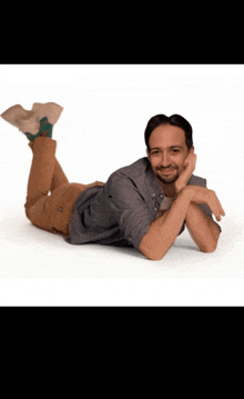 a man is laying on his stomach with his legs crossed and his head resting on his hand