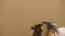 a stuffed animal is using a stanley hammer to break a hole in the wall