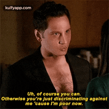 a man without a shirt is talking to a woman while standing next to her .