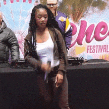 a woman is standing in front of a banner that says festival