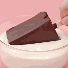a slice of chocolate cake is sticking out of a glass of milk