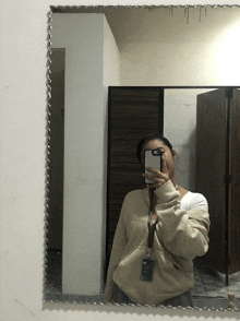 a woman taking a selfie in front of a mirror