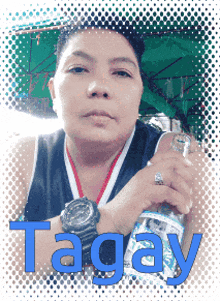 a woman is holding a bottle of tagay water in her hand