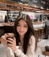 a woman is holding a cup of coffee and smiling