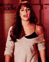 a woman is standing in front of a sign that says " dressing rooms "