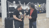 two men are standing next to each other in a hallway and one of them is wearing a shirt that says beyond punk revolution