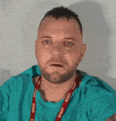 a man with a beard and a lanyard that says staff on it .