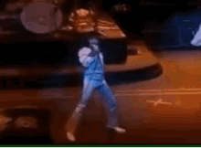 a man is standing on a stage holding a microphone and dancing .