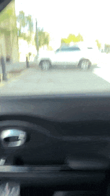 a white suv is parked in a parking lot behind a building