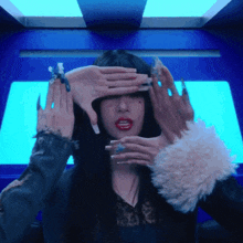 a woman covering her eyes with her hands in a blue room