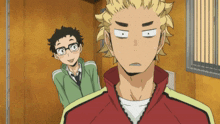 a man with glasses is standing next to another man with a red jacket