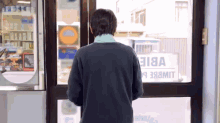 a person standing in front of a window with a sign that says vbie