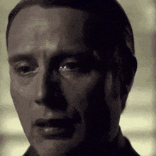 a close up of a man 's face with tears coming down his face .