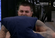 a man in a blue shirt is hugging another man in a blue shirt with the caption commenta con #granhermanochv on the bottom