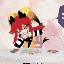 a cartoon character with red hair is sitting at a table with cards on it