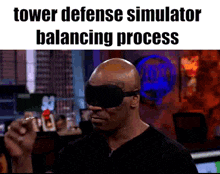a bald man wearing a blindfold and a tower defense simulator balancing process .