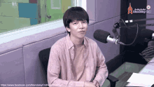 a man is sitting in front of a microphone in a radio studio
