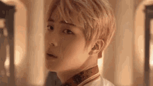 a close up of a young man 's face with blonde hair .