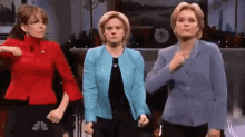 three women are standing next to each other in a room and dancing .
