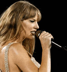 a woman is singing into a microphone with the word taylor on it