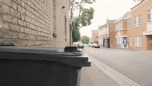 a trash can is sitting on the side of the road