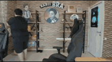 a man is standing in a room with a sign that says baris bra on it