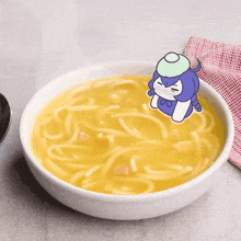 a bowl of noodles with a cartoon cat on top