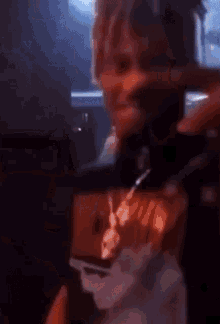 a man with dreadlocks is taking a picture of himself with his cell phone .