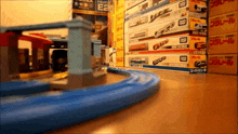 boxes of tomy toys are stacked on a wooden floor