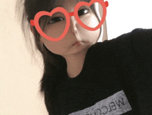 a girl wearing heart shaped glasses with the word welcome on her shirt